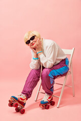 Dreamy look. Beautiful old woman, grandmother in stylish sportive trousers posing on vintage...