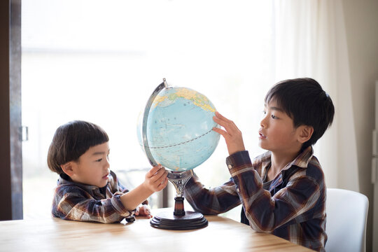 地球儀を見る兄弟