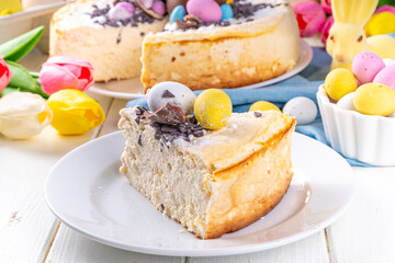 Homemade Easter cheesecake, sweet cottage cheese baking, with Easter chocolate eggs and chocolate drops, with holiday decorations and spring flowers