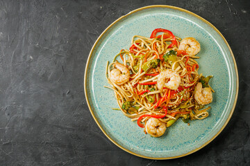 fried wok shrimp noodles on a black rustic background