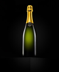 Unlabeled champagne bottle with gold foil. Studio shot on black background, copy space