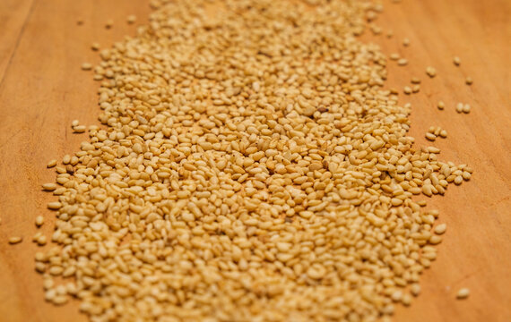 Organic sesame seeds isolated on a wooden cutting board