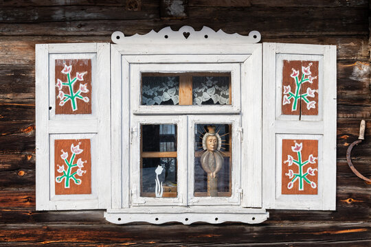 Beautiful window of an old traditional wooden house in the village of Margionys, Dzūkija or Dainava region, Lithuania, with tulips and flowers painted on the doors