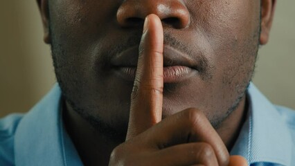 Close up part face man silent mysterious african american 30s male businessman put finger to lips make silence hush gesture mystery not saying keep secret stop talk privacy information tell secrecy