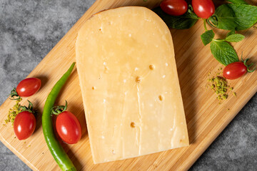 Gouda cheese. Piece of gouda cheese on wooden cutting board. Cheese collection. Ripe hard cheese...