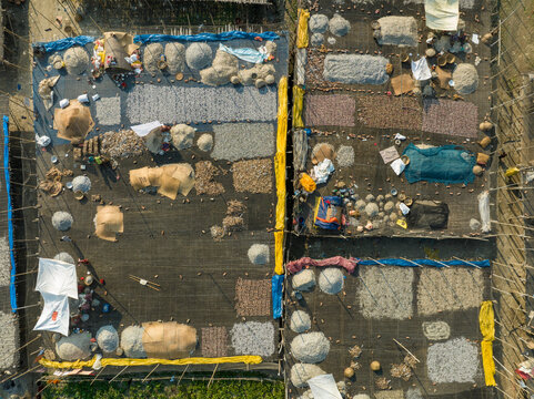 Aerial view of people working in a fish market drying fish at Lalpur Launch Ghat along Meghna River, Chattogram, Bangladesh.