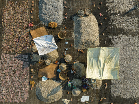 Aerial view of people working in a fish market drying fish at Lalpur Launch Ghat along Meghna River, Chattogram, Bangladesh.