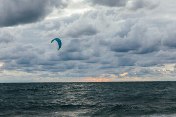 man at sea parachute in storm sky in clouds of nature
