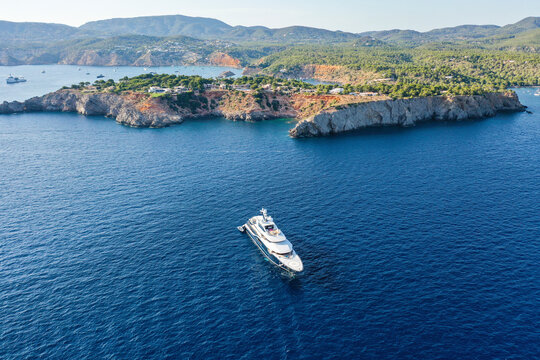 Aerial view of big motor yacht in the Mediterranean sea along the coast in Ibiza, Balearic Island, Spain.