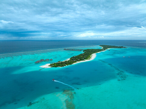 Aerial view of a boat sailing along the coastline on Huluwalu Island, Maldives archipelagos.