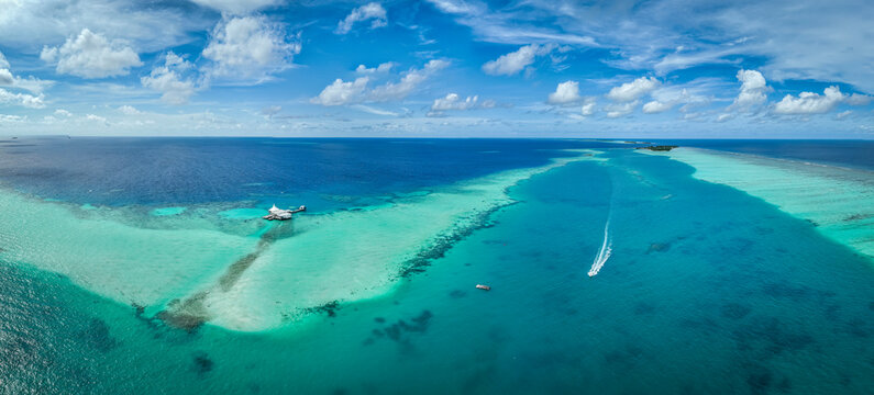 Aerial view of a sailing boat navigating along Huluwalu Island, Maldives archipelagos.