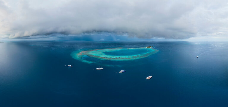 Panoramic aerial view of luxury yachts docked along the Atoll on Maldives archipelagos.