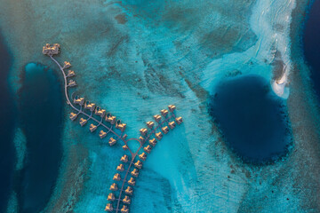 Aerial view of a luxury resort with bungalow on a small island in the Laccadive Sea at night, Indian Ocean, Maldives archipelagos.