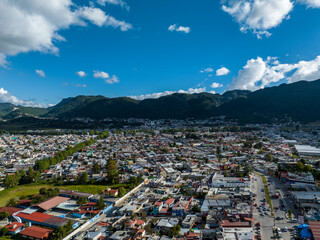 Fototapeta na wymiar Aerial view of colorful mountain village of San Cristobal de Las Casas in Mexico. Clouds over the mountains. Panorama.