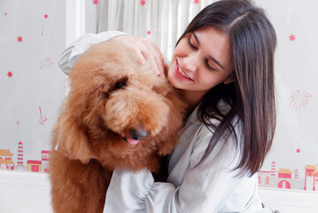 Smiling woman hugging a cute brown dog dog love concept.