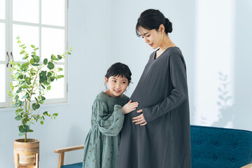 妊婦ママのお腹に耳を当てる女の子