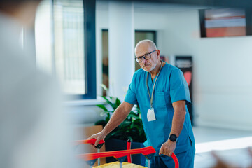 Elderly caregiver pushing hospital bed at corridor.