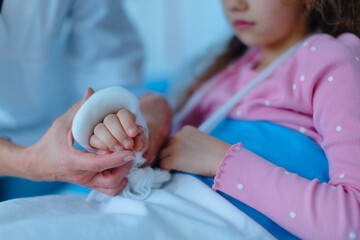 Doctor examining little girl with broken arm.