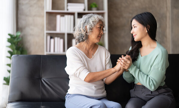 Daughter Talking To Sad Mother Holding Hand Comforting Upset Having Problem