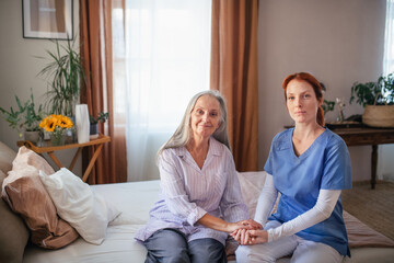 Portrait of nurse holding hand to senior client.