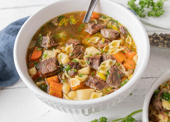 Homemade Beef soup with vegetables and noodles in bowl. 