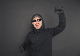 Screaming Man in the black hoody with hood wearing sunglasses with fist up