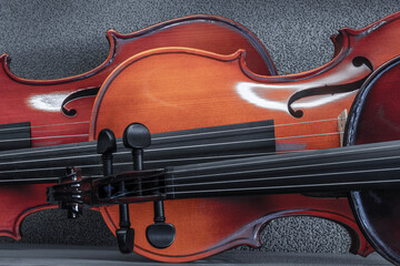 Violin display in a row horizontally. The violin is an important musical instrument because of its fundamental role in classical music.