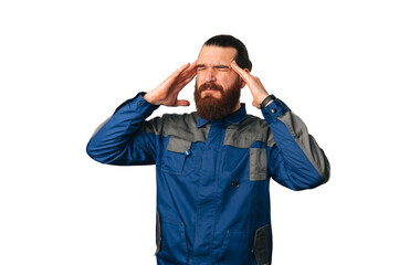 Handsome bearded man wearing handyman uniform is having a bad headache over white background.