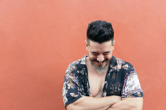 Laughing bearded man against bright wall
