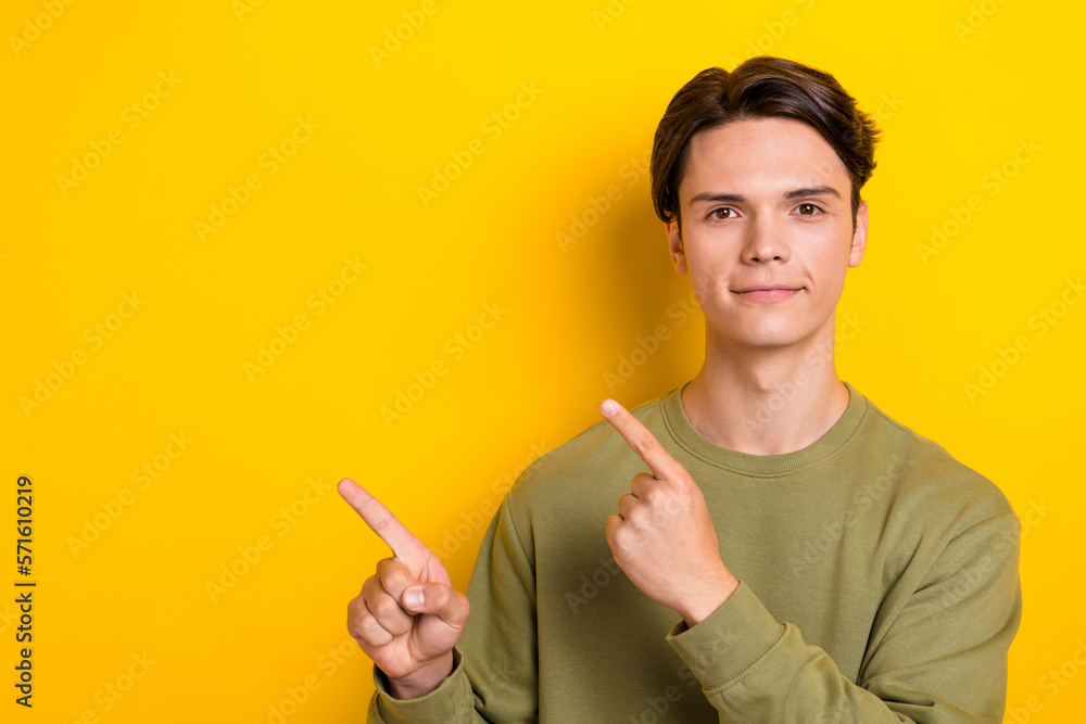 Sticker Photo of positive young man direct fingers empty space proposition isolated on yellow color background