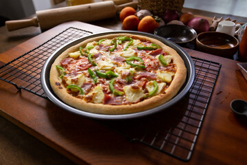 Top view of fresh baked homemade pizza on wooden table with ingredients and spices. Delicious italian pizza is ready for deliver..