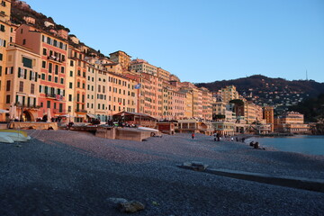 Camogli, Italy - January 27, 2023: Beautiful old mediterranean town at the sunrise time with illumination during winter days.
People enjoying the evening at the beach with beautiful sunset background