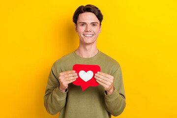 Photo of cheerful man influencer wear khaki clothes hold red card instagram facebook like isolated...