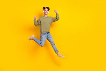 Fototapeta na wymiar Full body photo of overjoyed energetic person jumping raise fists empty space isolated on yellow color background