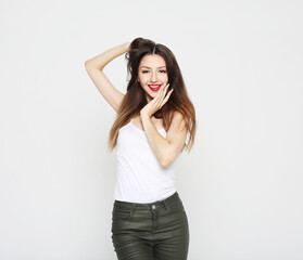 charming smiling young woman with long fark hair dressed in a white t-shirt and jeans