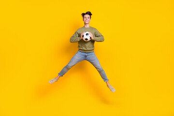 Full body portrait of carefree crazy person jumping hands hold football isolated on yellow color background