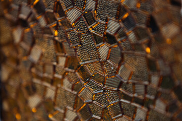 Close up photo of stained glass window under sunlight, it's shining amber colours on the light.
