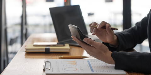 Close-up of the hands of a business woman using a calculator to check financial accounts check the company's expenses and budget.