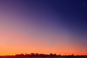 Sunset on the clear sky. Color gradient of the morning sky. Dusk sky with stars above horizon. Beautiful bright sunrise on the sky, background.
