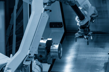 The automatic  robotic arm gripping the metal parts from CNC lathe machine.