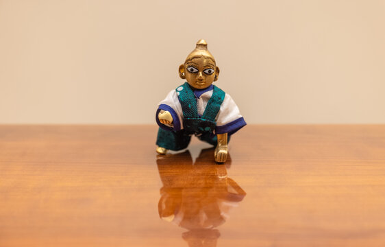Lord Krishna brass made idol on table. Selective focus on face.