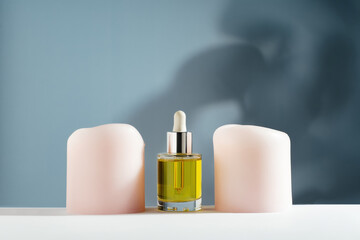 yellow face and hair oil with candles on blue background