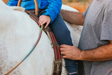 Close up view of a boy riding a horse in an assisted equine therapy session.