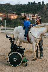 Boy with disabilities sitting on a horse while having his equine therapy.