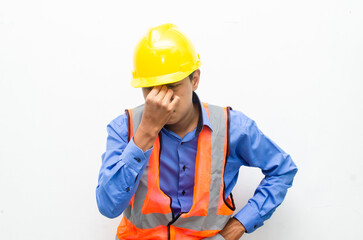 stressed over work concept illustrated by asian male construction worker in blue shirt, orange vest and yellow safety helmet with furious, mad, sad, angry expression. overworked concept