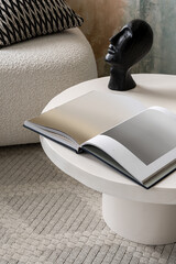 Sculpture and album on stone coffee table, close-up