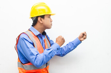 side view of stressed over work concept illustrated by asian male construction worker in blue shirt, orange vest and yellow safety helmet with furious, mad, sad, angry expression. overworked concept