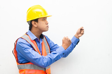 side view of stressed over work concept illustrated by asian male construction worker in blue shirt, orange vest and yellow safety helmet with furious, mad, sad, angry expression. overworked concept