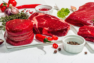 Set of various steaks with spices and herbs. Ribeye, eye round, flank and striploin steaks