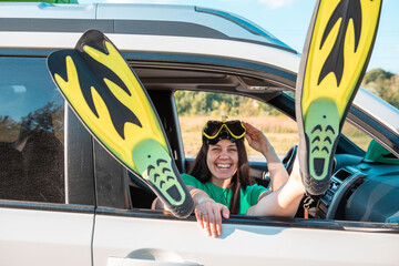 happy woman in scuba mask stick out legs in flippers car travel sea vacation